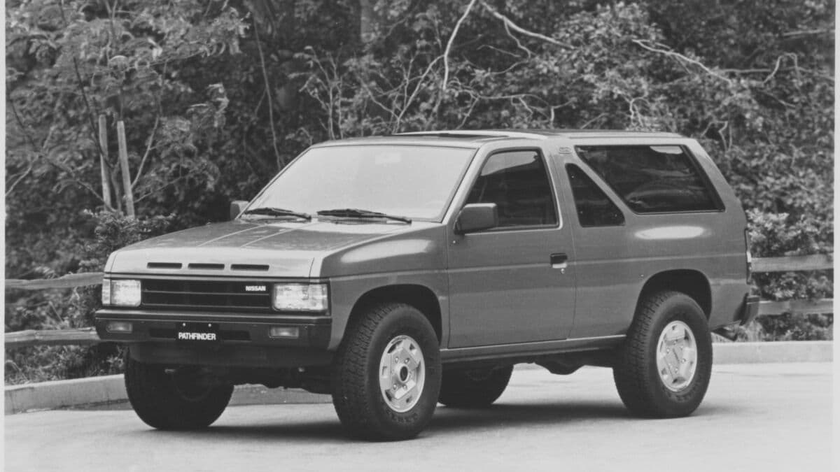 1987 Nissan Pathfinder parked near woods.