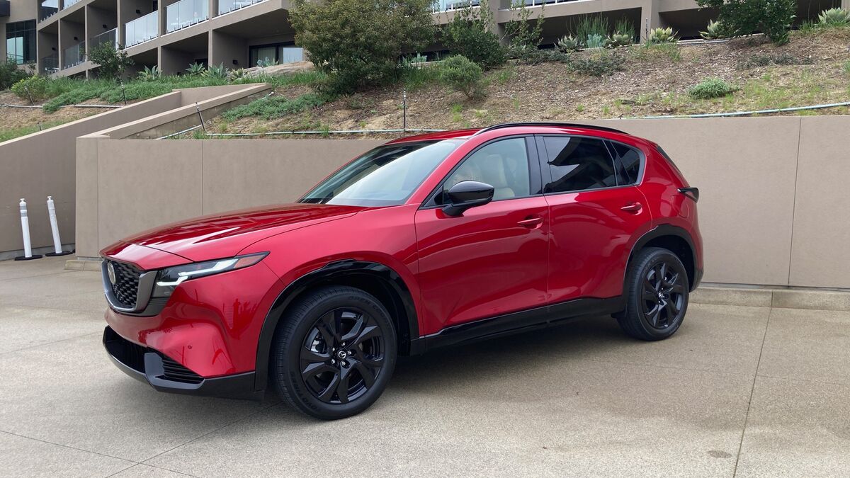 A 2026 Mazda CX-5 front three-quarter view from the driver's side with a building in the background
