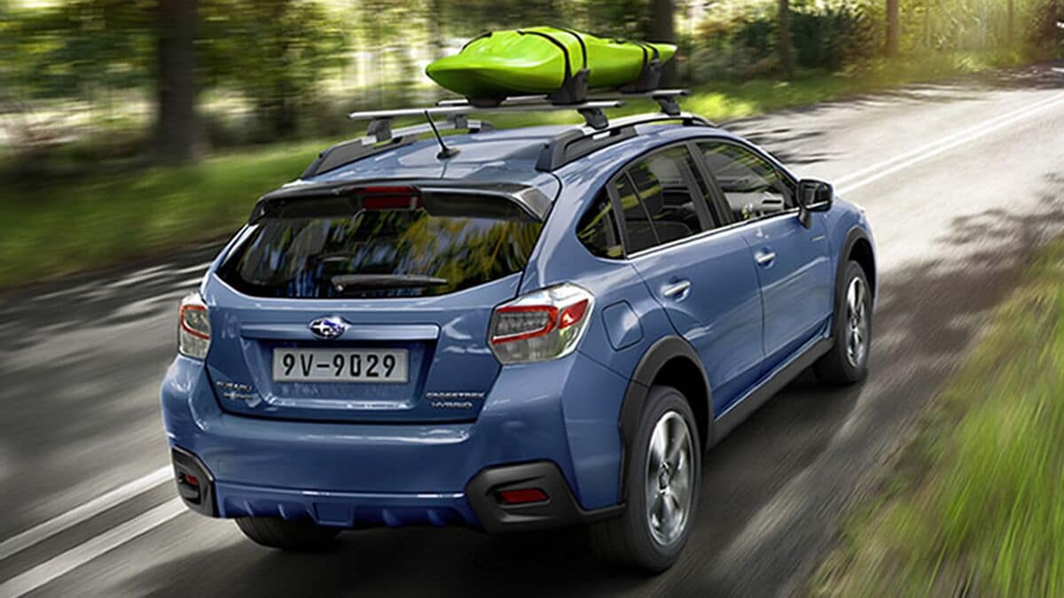 2016 Subaru Crosstrek driving down a road.