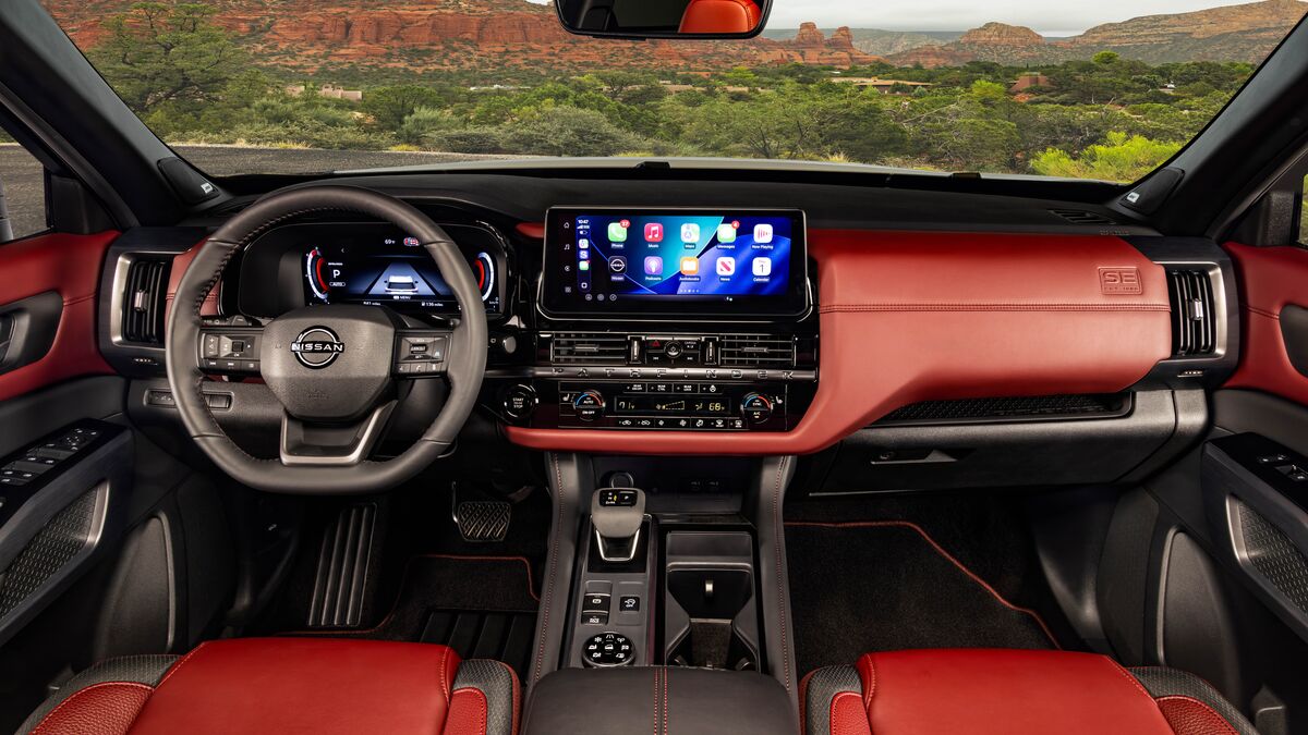 2027 Nissan Pathfinder Special Edition in red looking out at rock formation.