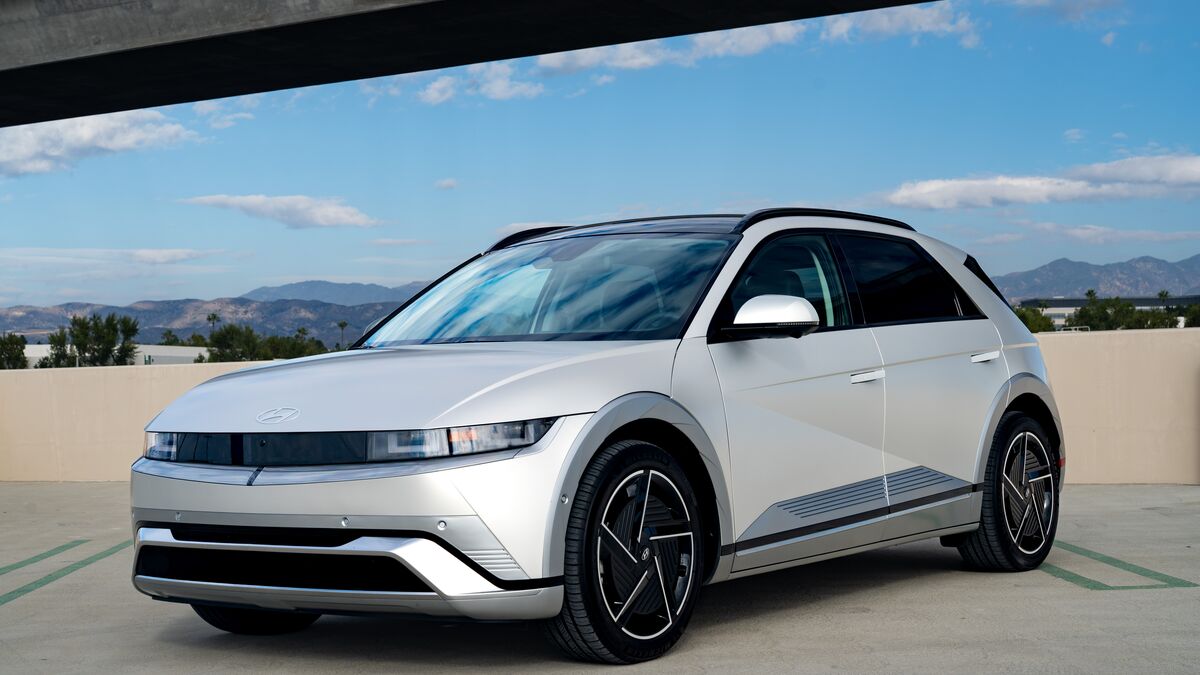 A front 3/4 view of the Hyundai Ioniq 5 parked on a cement parking structure on a sunny day.