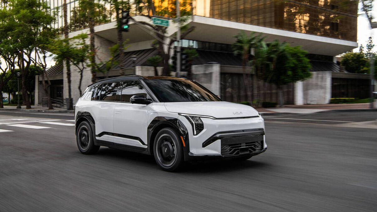 2027 Kia EV3 driving past a building.