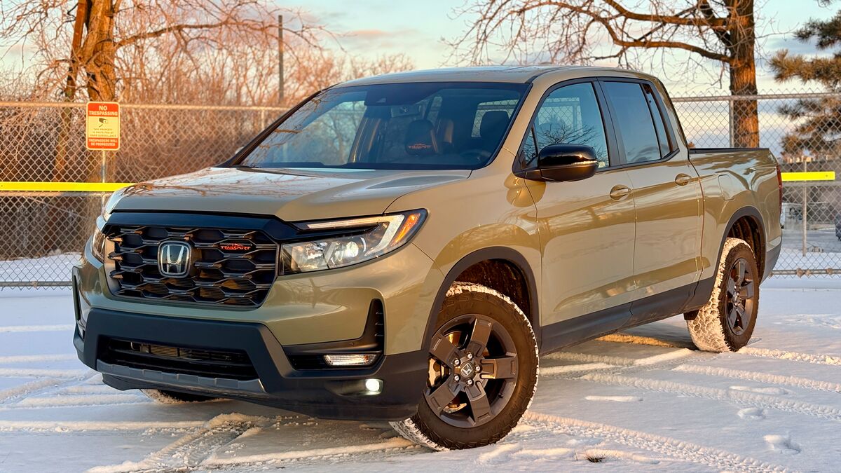 2026 Honda Ridgeline Trailsport parked on snow by a fence.