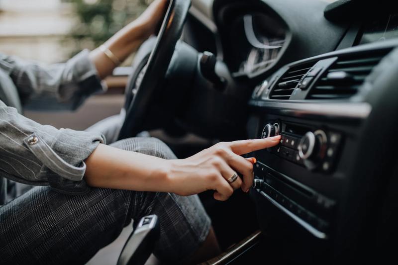 Driver pressing air conditioning button.