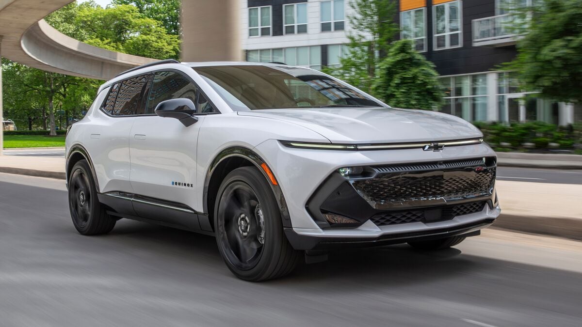 A white 2026 Chevrolet Equinox EV driving.