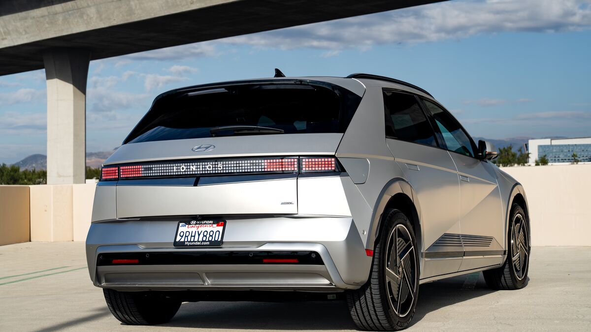 A rear 3/4 view of the Hyundai Ioniq 5 parked on a cement parking structure on a sunny day.