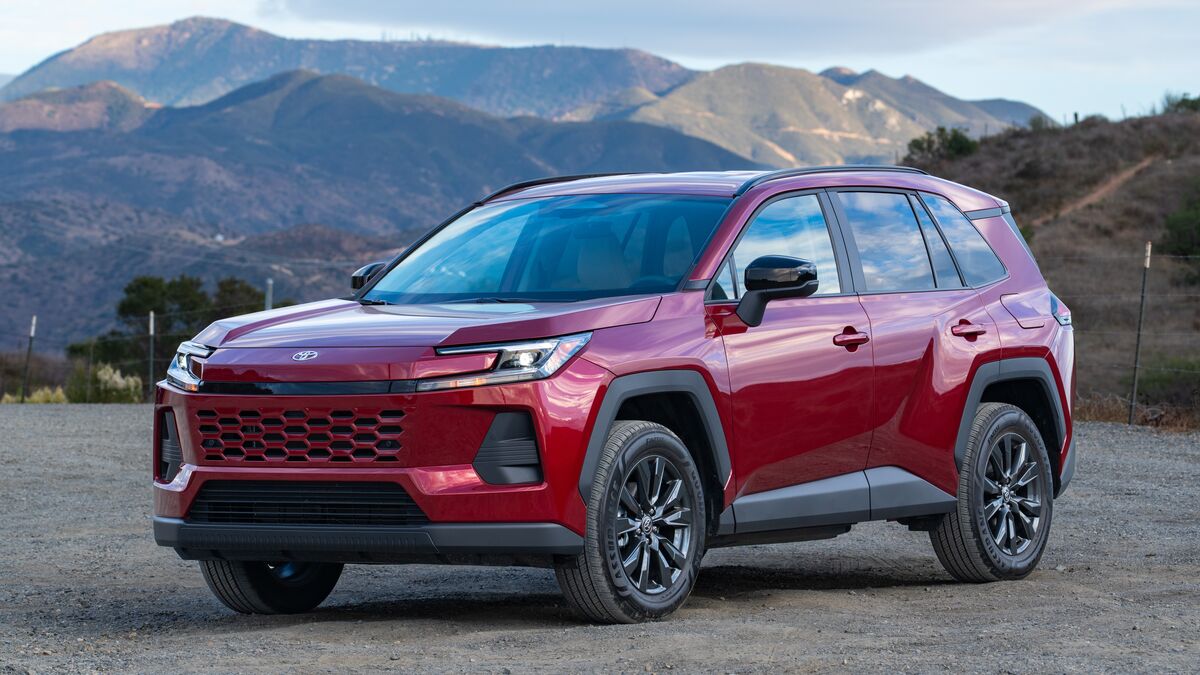 A front left 3/4 angle photo of a 2026 Toyota Rav4 XLE after sunset against a hilly backdrop under blue skies.