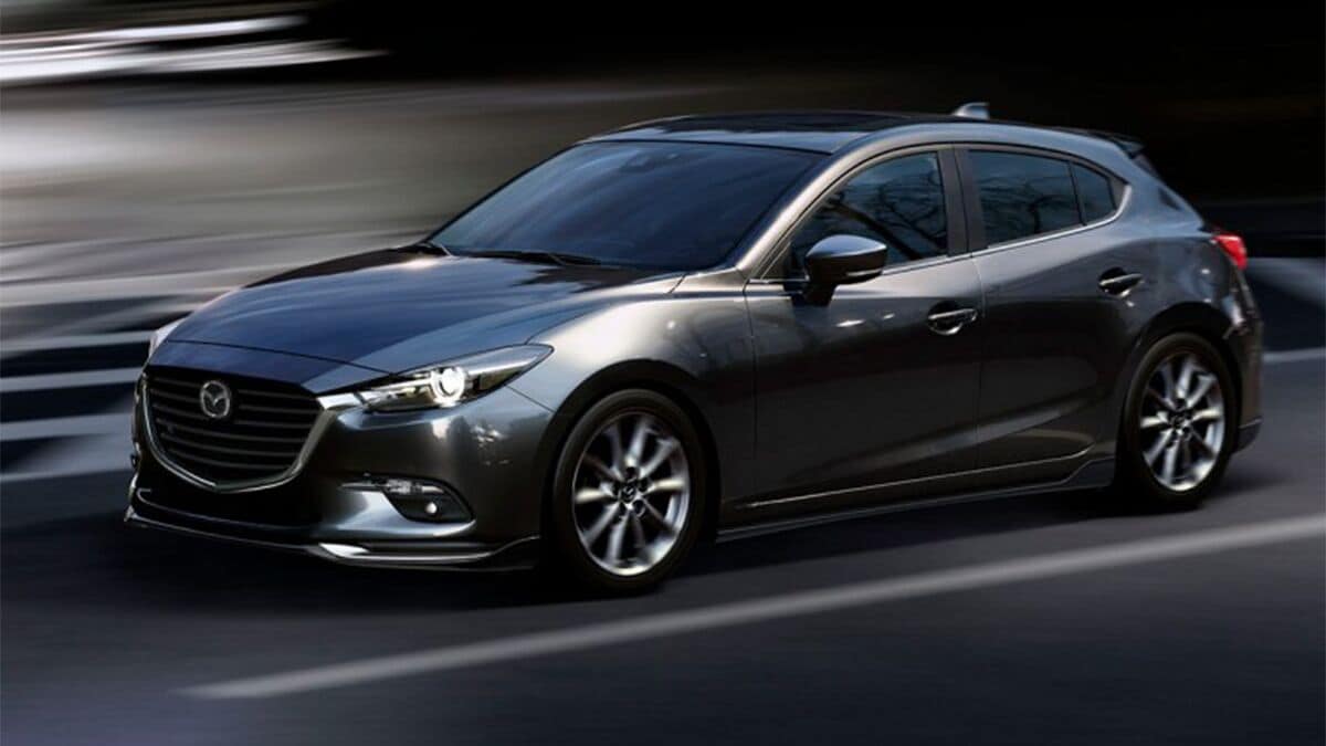 2018 Mazda3 in charcoal, driving down the road.