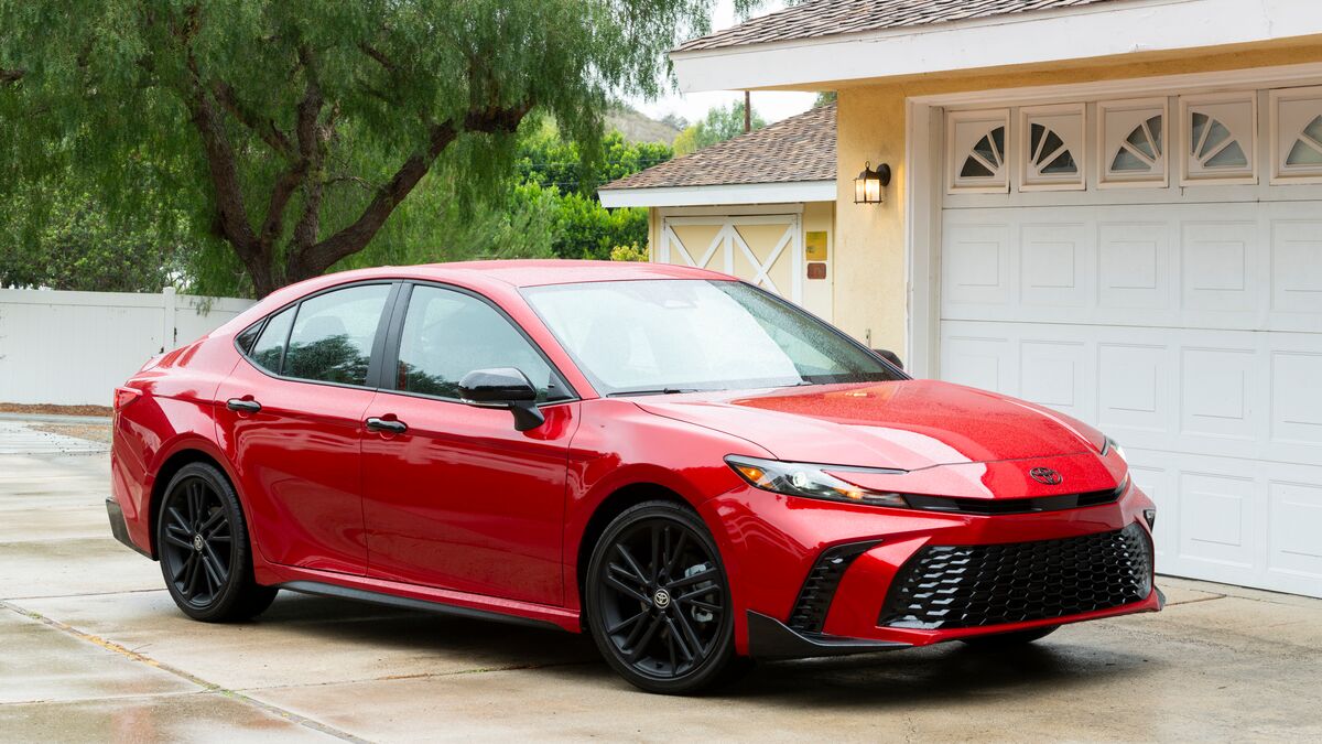 2026 Toyota Camry in red parked in front of a garage.