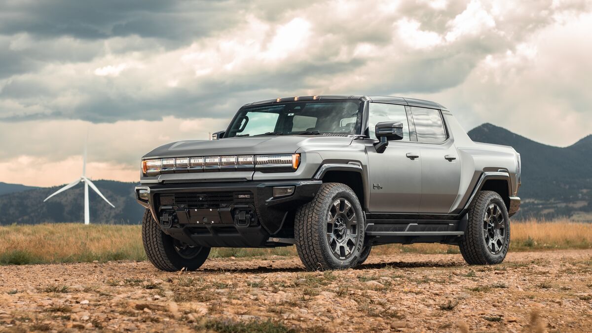 2026 Hummer EV pickup front 3 quarter angle with wind turbine in background