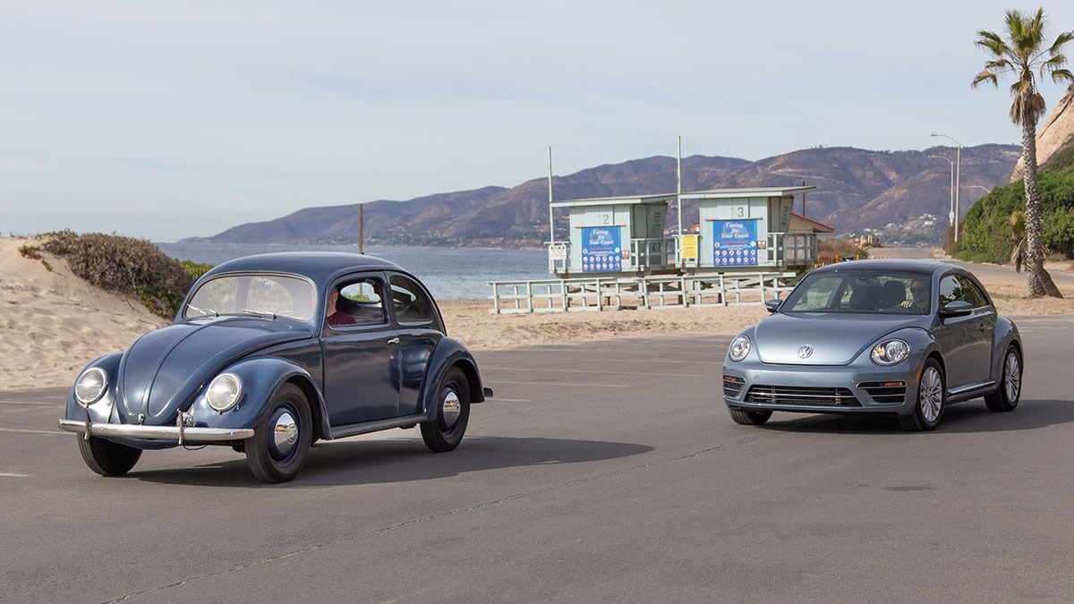 Volkswagen Beetles parked by a beach.