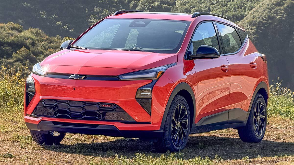 2027 Chevy Bolt in red parked on grass.