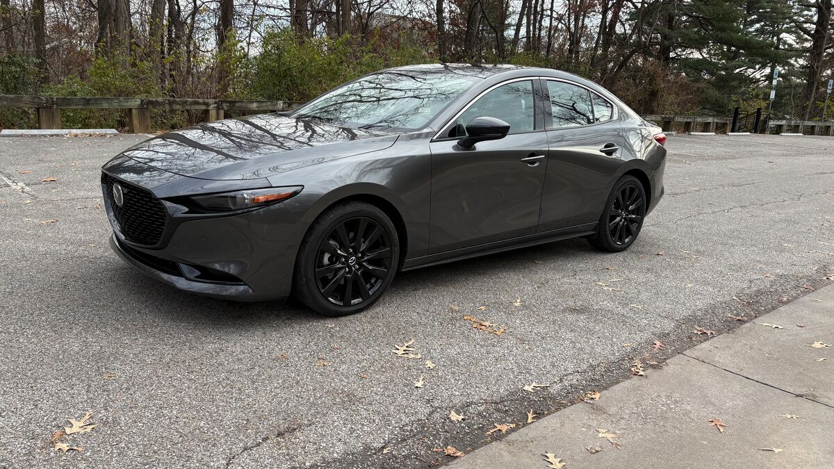 2026 Mazda3 parked on the road by trees.