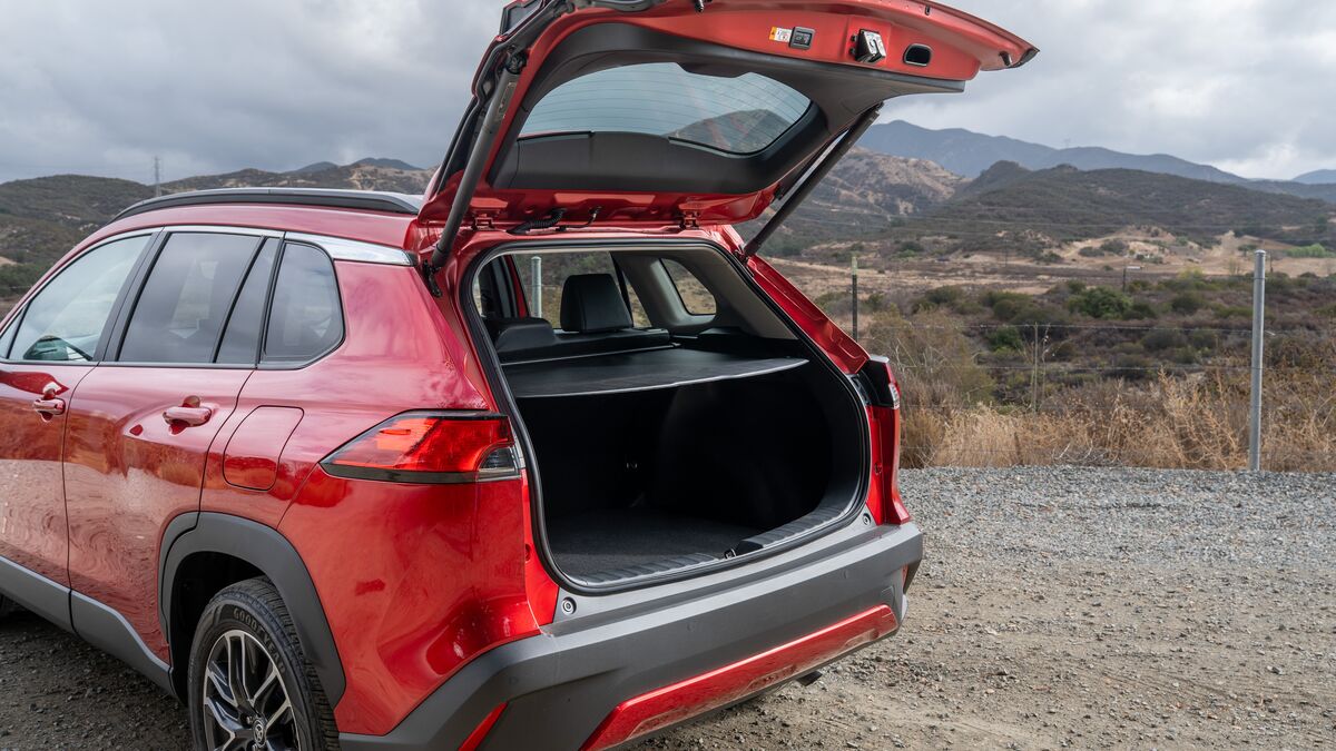 2026 Toyota Corolla Cross rear hatch open 3/4 view against a mountainous landscape backdrop