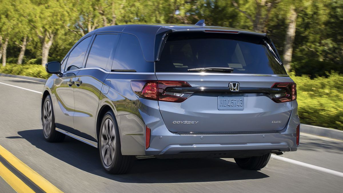 2025 Honda Odyssey driving down a road.
