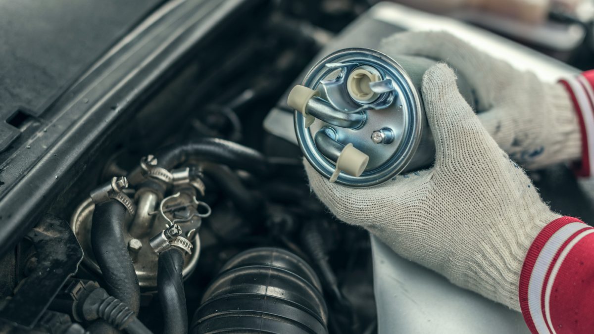 A mechanic replacing a fuel filter