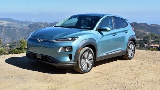 Blue 2019 Hyundai Kona Electric parked on hill top.