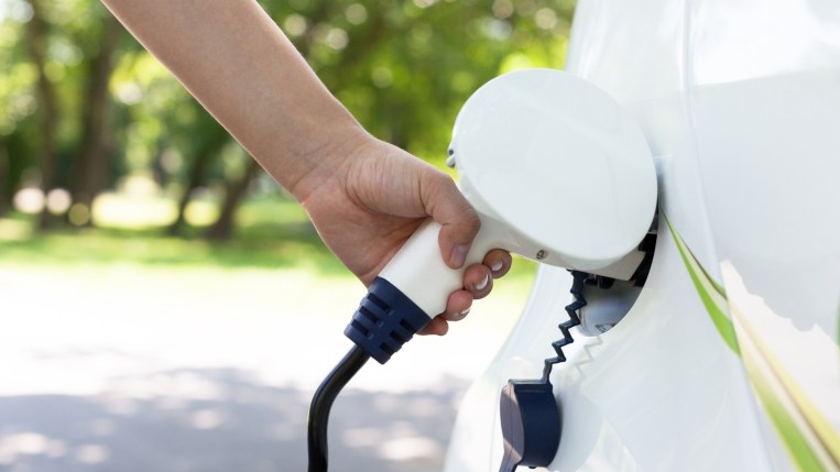 An electric car being charged at a car charging station.