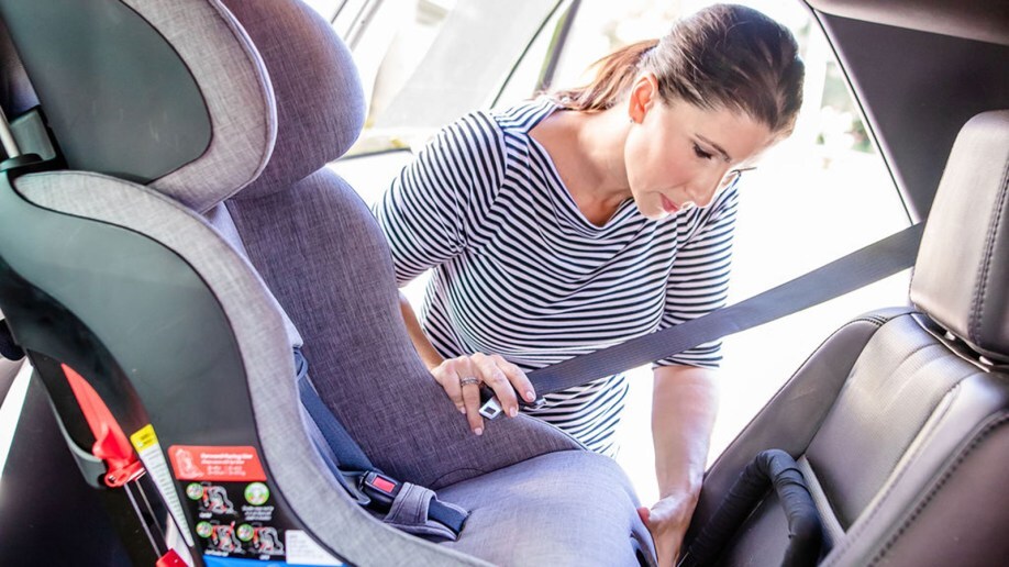 Mother installing car seat
