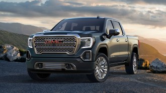 2021 GMC Sierra Denali with green hills in the background.