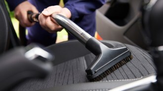 Man Hoovering Seat Of Car During Car Cleaning for Selling a car online