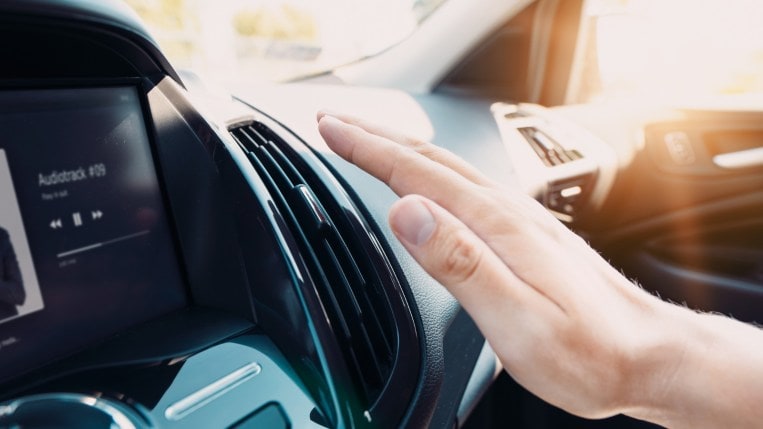 Car owner checking air conditioning temperature