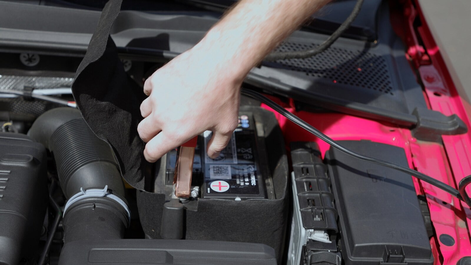 A person disconnecting jumper cables.