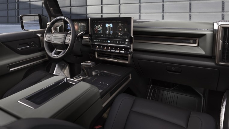 The interior of the 2022 GMC Hummer EV. It is upholstered in black leather with a huge central touchscreen. GM has said it may add up to 50 value-added, downloadable products to its cars.