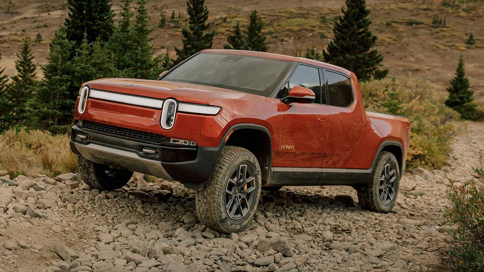 The 2022 Rivian R1T pickup in red after a drive through the mud