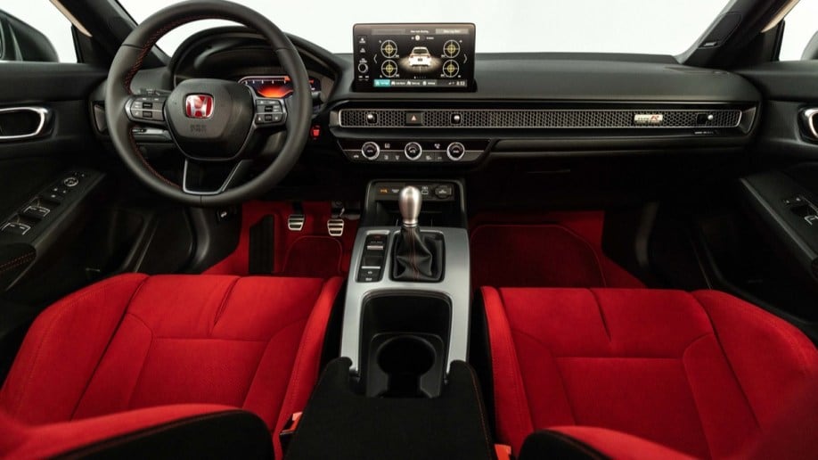 The cabin of the 2023 Honda Civic Type R. The dashboard is black and the seats are upholstered in a dramatic, attention-grabbing bright red.