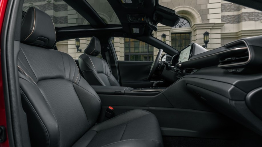 The interior of the 2023 Toyota Crown. It is upholstered in black SofTex, a leather-like material. The transmission tunnel dividing driver from front passenger is tall, creating a deep bathtub feel for both.