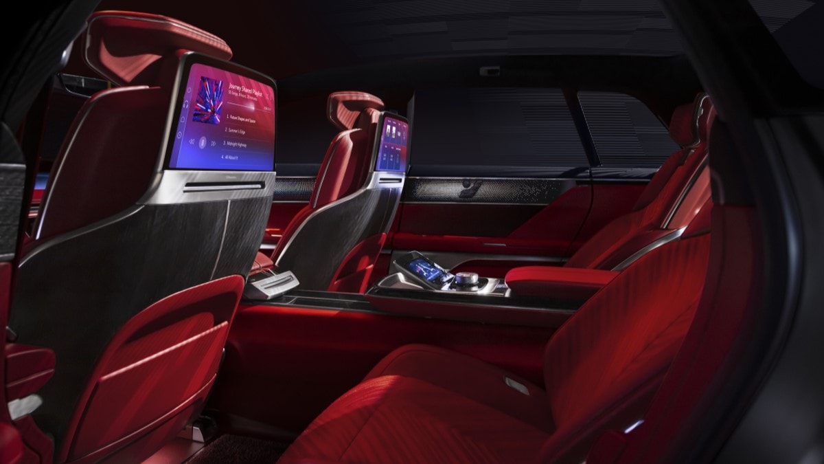 The interior of the Cadillac Celestic show car. We see the backs of the front seats, shaped from sleek metal, with screens to keept the rear passengers entertained.