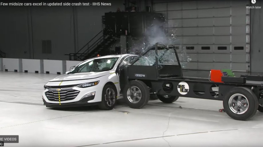 A screenshot of the Insurance Institute for Highway Safety's side-impact crash test of the 2022 Chevy Malibu, showing the sled hitting high on the car's side windows