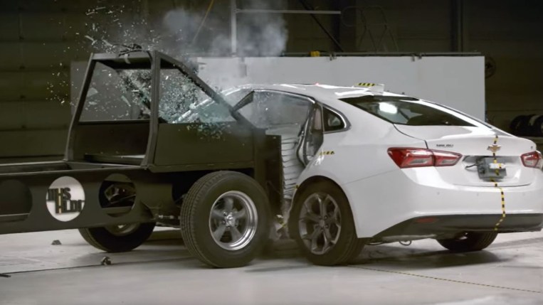 La Chevy Malibu 2022 subit des essais de collision latérale dans un laboratoire de l'Insurance Institute for Highway Safety.  Nous voyons le traîneau d'essai s'écraser sur le côté de la Malibu, qui a obtenu un score de 