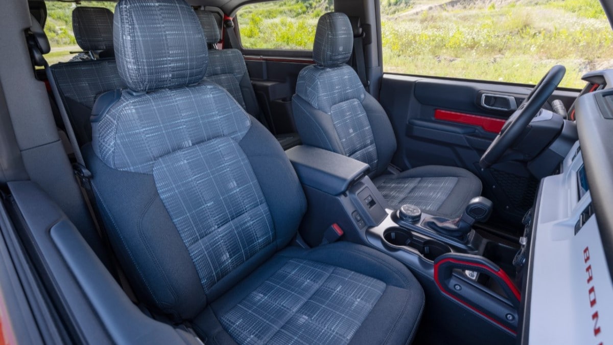 The interior of the 2023 Ford Bronco Heritage Edition. It features a dashboard finished in white and grey plaid seats.