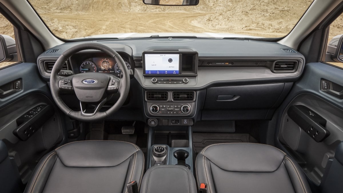 The interior of the Ford Maverick Tremor. The seats are black leatherette, with bright orange stitching.
