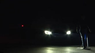 A car stops just short of hitting a mannequin during IIHS nighttime testing of automatic emergency braking systems