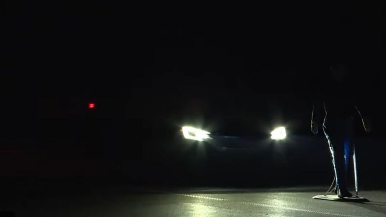 A car stops just short of hitting a mannequin during IIHS nighttime testing of automatic emergency braking systems