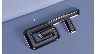 A teaser shot showing a badge on the trunk lid of the 2024 Ford Mustang