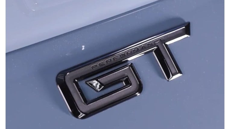 A teaser shot showing a badge on the trunk lid of the 2024 Ford Mustang