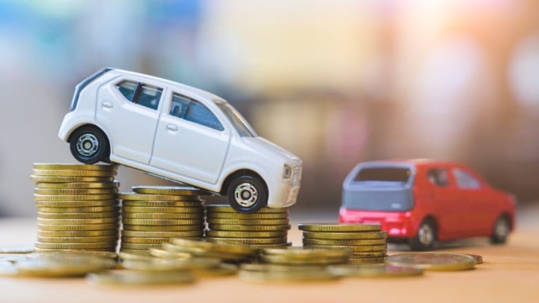 A toy car sits on stacks of coins