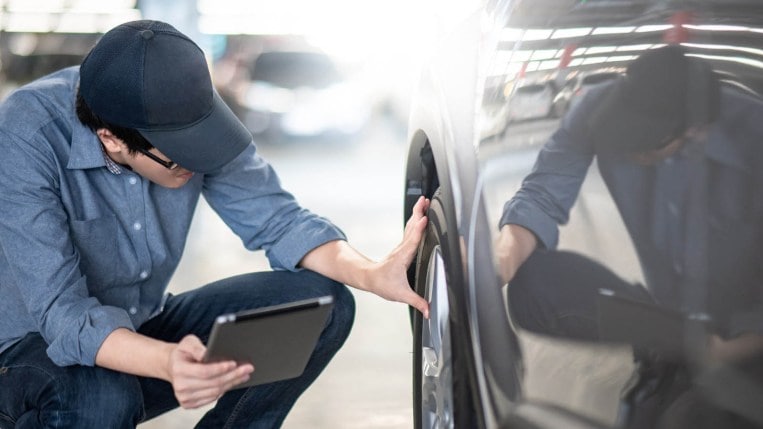 Mechanic inspecting car wheel