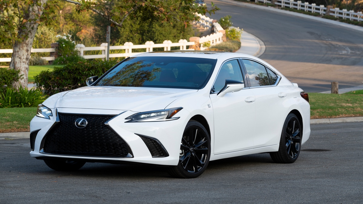 White 2023 Lexus ES 300h parked near curved fence