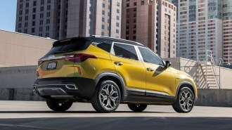 Gold 2023 Kia Seltos parked near office buildings