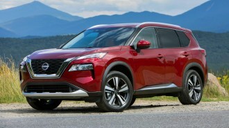 Red 2023 Nissan Rogue near grass.