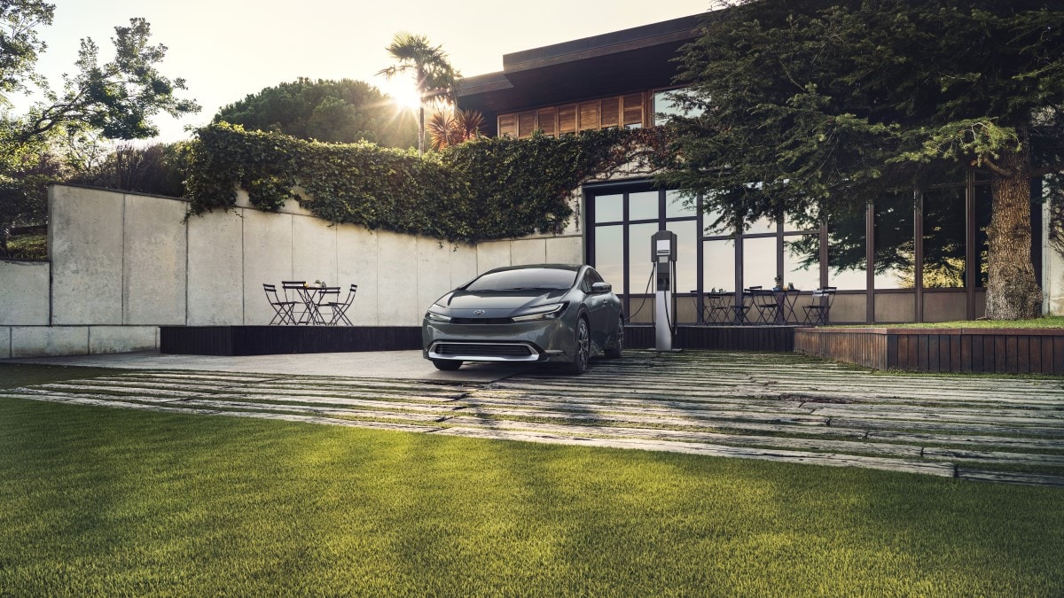 The 2023 Toyota Prius Prime, seen from a front quarter angle, plugged in to charge