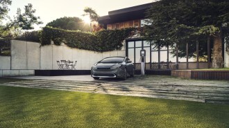 The 2023 Toyota Prius Prime, seen from a front quarter angle, plugged in to charge