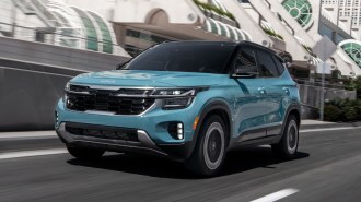 Light Blue 2024 Kia Seltos driving by convention center