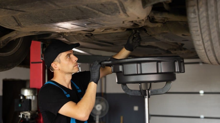 A technician working to change the oil in a car.