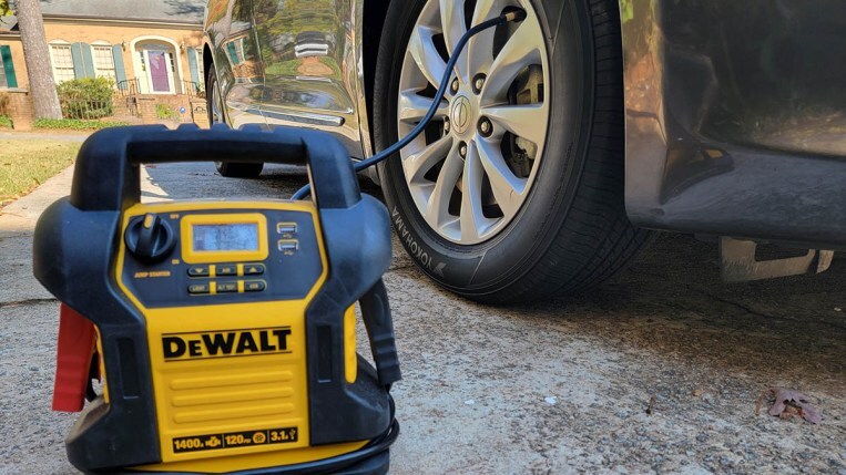 A portable air compressor pumping air into a car tire.